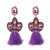Stunning purple tassel earrings crafted from gold and purple crystals, showcasing a chic fringe drop design with cubic zirconia.